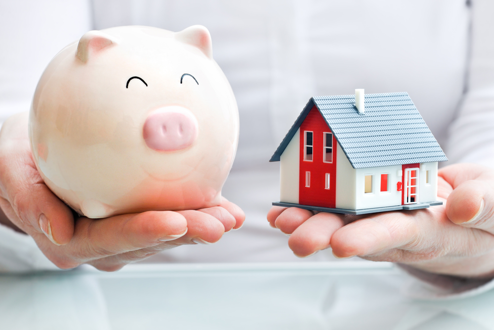 Tax Lawyer St. Johns County, FL - Hands holding a piggy bank and a house model